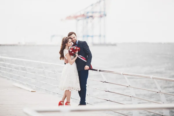 Casamento casal apenas andando na praia ao pôr do sol . — Fotografia de Stock