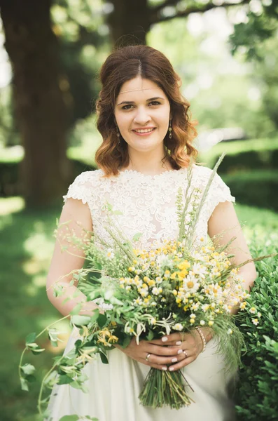 La novia sosteniendo ramo de flores en el parque. Boda — Foto de Stock