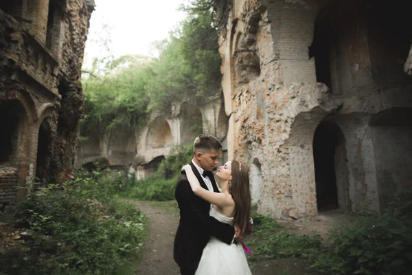 Šťastní novomanželé nedaleko starobylého hradu na procházku — Stock fotografie