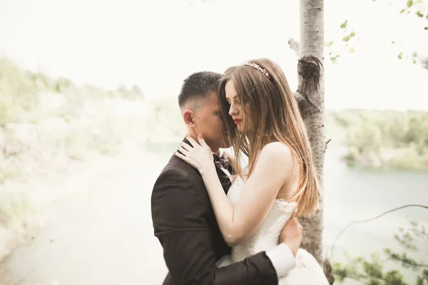 Gyönyörű menyasszony, vőlegény, csók és átölelve közelében, lenyűgöző kilátással a sziklákra — Stock Fotó
