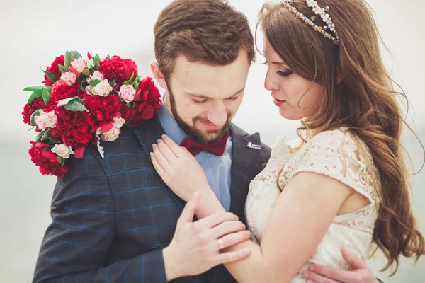 Matrimonio sposato coppia in piedi su un molo sul mare — Foto Stock