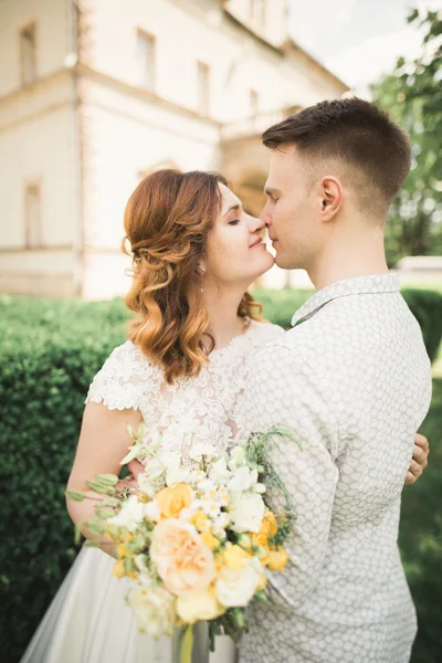 Schönes romantisches Brautpaar, das sich in der Nähe des alten Schlosses umarmt — Stockfoto