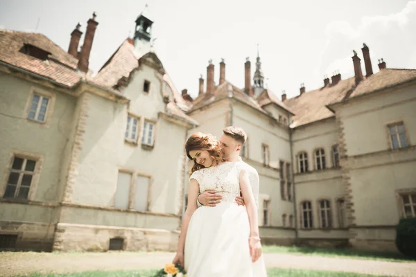 Hermosa boda romántica pareja de recién casados abrazos cerca del viejo castillo —  Fotos de Stock