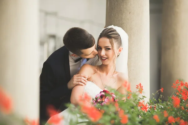 Ravissant couple de mariage heureux, mariée avec longue robe blanche posant dans la belle ville — Photo