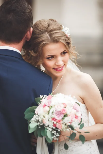 Čerstvě vdaná, svatební pár, pózování a nevěsta drží v ruce kytici — Stock fotografie