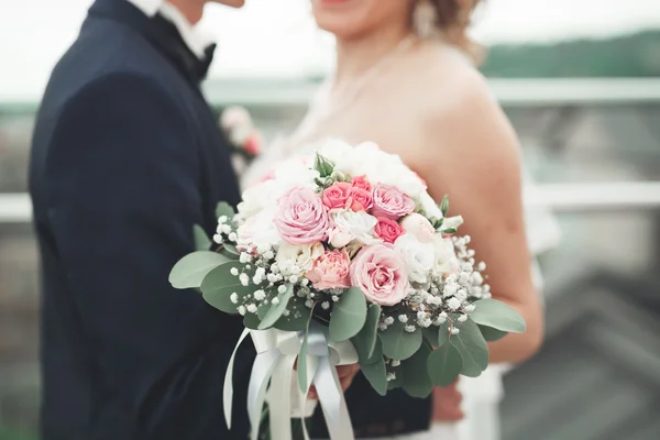 Casamento apenas casal posando e noiva segurando em mãos buquê — Fotografia de Stock