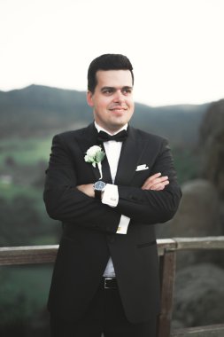 Şık adam, dağlar arka plan üzerinde poz damat