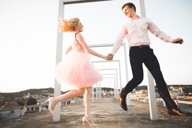 Sevgi dolu çift atlama ve eski şehir'in backgrounf ile çatı üzerinde gülümseyen