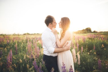 Güzel düğün çift, aşk günbatımı üzerinde. Fielf çiçekli