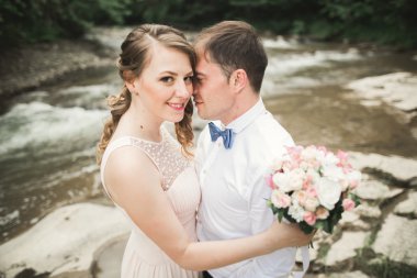 Gelin ve damat güzel düğün buket tutarak. Göl, orman