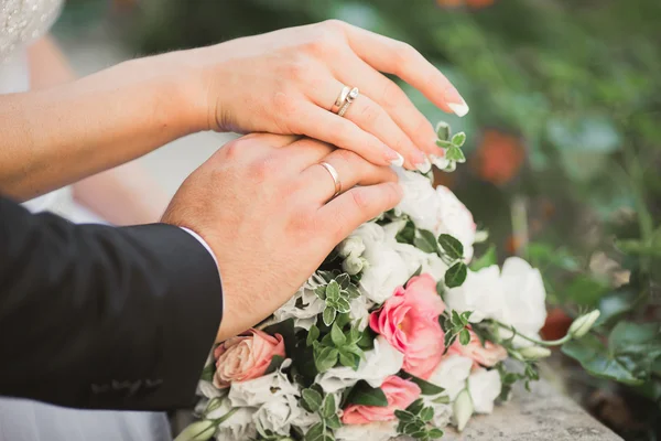 Gelin ve damat el ele tutuşuyor.
