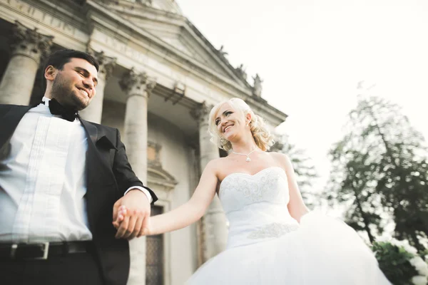 Feliz casamento casal abraçando e beijando no fundo velho castelo — Fotografia de Stock