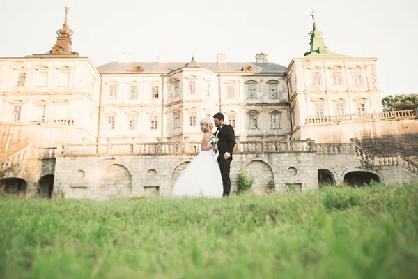 Hermosa boda romántica pareja de recién casados abrazos cerca del viejo castillo — Foto de Stock