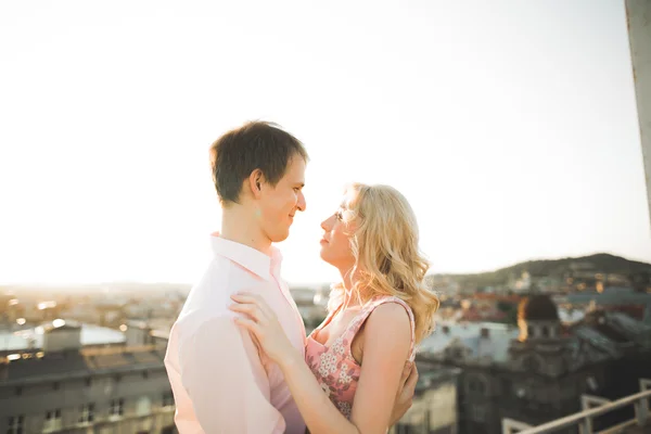 Close up retrato de feliz casal sorridente no amor posando no telhado com grandes bolas. Paisagem cidade — Fotografia de Stock