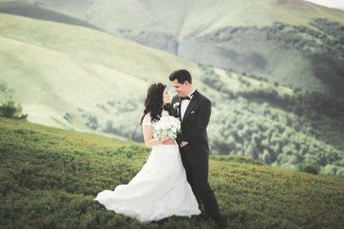 Güzel düğün çift, gelin ve damat, arka planda dağların aşık