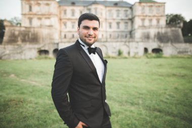 Arka plan eski kale üzerinde poz şık damat