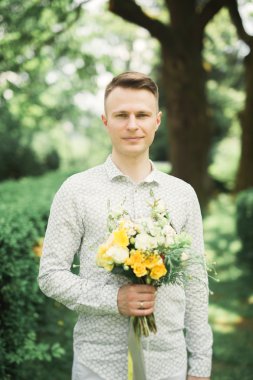 Adam, mükemmel bir düğün buket ile poz damat