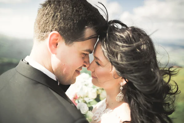 Schönes Hochzeitspaar küsst und umarmt sich in der Nähe des Berges mit perfekter Aussicht — Stockfoto