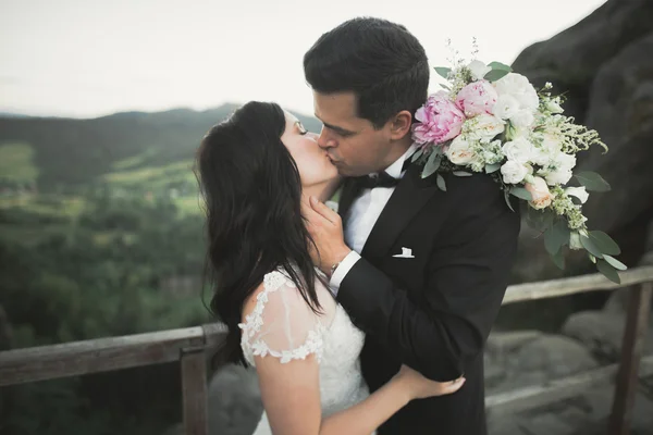 Casal feliz beijando e abraçando perto de um penhasco alto — Fotografia de Stock