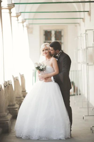 Bella coppia di nozze felice, sposa con abito lungo bianco in posa nella bella città — Foto Stock