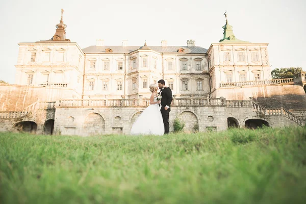 Bella coppia di sposi romantici che si abbracciano vicino al vecchio castello — Foto Stock