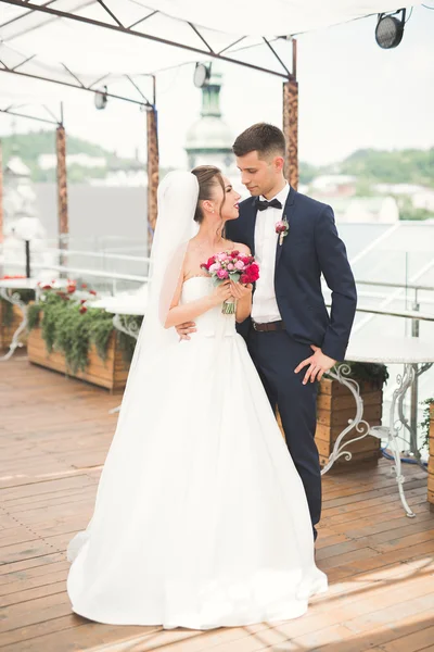 Bella coppia, sposa e sposo in posa sul balcone con backgrounf della città vecchia — Foto Stock