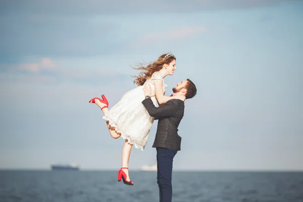 Feliz recém-casado jovem casal de casamento celebrando e se divertir no belo pôr do sol da praia — Fotografia de Stock