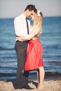 Genç mutlu çift holding birbirlerini etrafında gülümseyen Sahilde yürüyüş. Aşk hikayesi