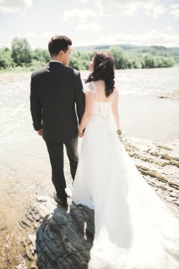 Gelin ve damat güzel düğün buket tutarak. Nehir kenarında poz