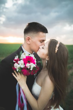 Düğün, güzel romantik gelin ve damat öpüşme günbatımında kucaklayan