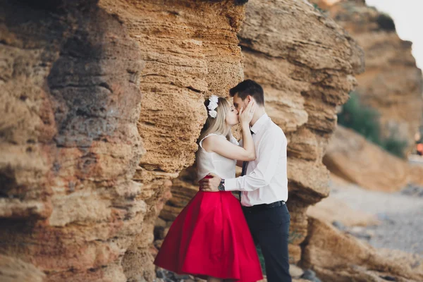 Romántica pareja amorosa caminando por la playa con rocas y piedras — Foto de Stock