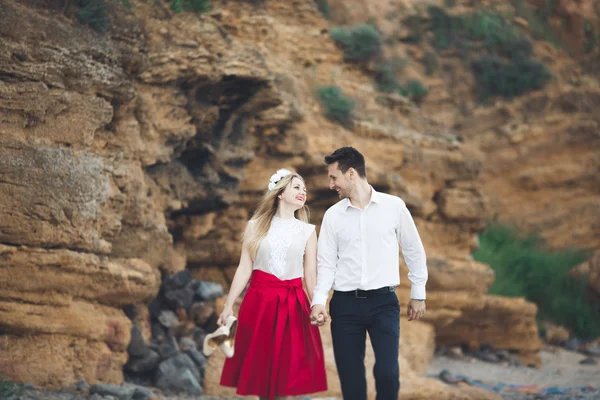 Romantik sevgi dolu çift kayalar ve taşlar Sahilde yürüyüş — Stok fotoğraf