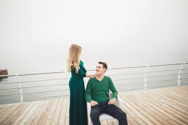 Preciosa pareja besándose y abrazándose en un muelle de mar — Foto de Stock