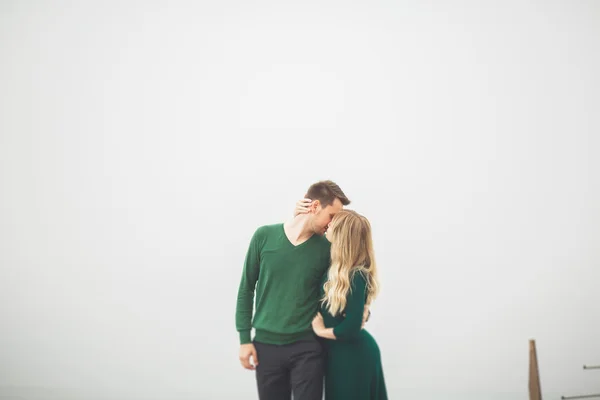Preciosa pareja besándose y abrazándose en un muelle de mar — Foto de Stock
