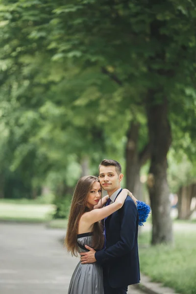 Unga vackra par, tjej med perfekta klänningen poserar i park — Stockfoto