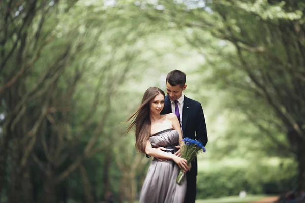 Joven hermosa pareja, chica con vestido perfecto posando en el parque —  Fotos de Stock