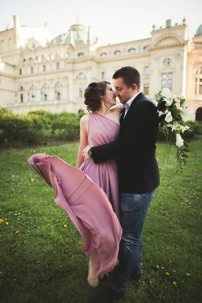 Hochzeit. Paar. Krakau. die Braut im rosa Kleid und der Bräutigam posieren vor dem Hintergrund des Theaters — Stockfoto