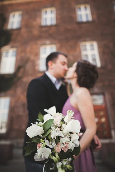 Bouquet de fleurs de mariage avec couple nouvellement marié sur fond — Photo