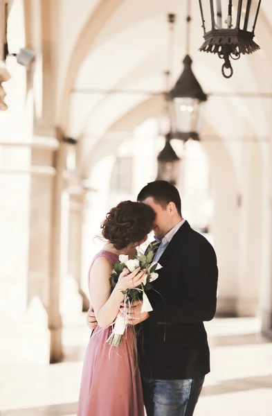Romantisches Hochzeitspaar, Mann und Frau, posiert in der Nähe von Altbaukolonnen — Stockfoto