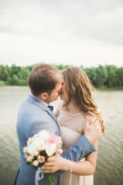 Gelin ve damat güzel düğün buket tutarak. Göl, orman