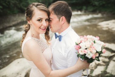 Mutlu çift düğün sarılma ve birbirlerine arka plan gölde gülümseyen orman