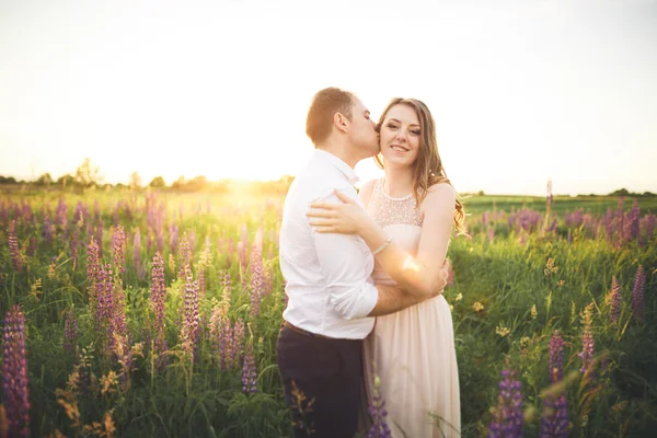 Gelin ve damat, çiçekler, güzel bir alanda gün batımında rissing romantik evli çift — Stok fotoğraf