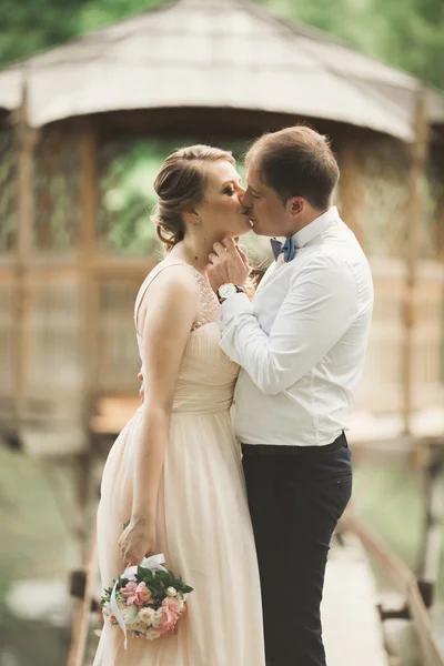 Жених целует невесту в лоб, когда она наклоняется к нему улыбаясь — стоковое фото