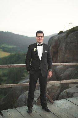Şık adam, dağlar arka plan üzerinde poz damat