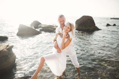 Deniz, mavi gökyüzü yakınındaki taş poz romantik sevgi dolu Çift