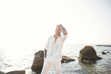 yakışıklı model adam taş denizin kenarında poz