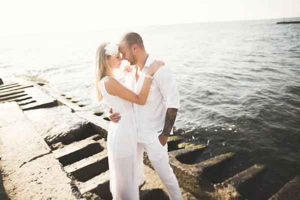 Felice appena sposato giovane coppia di nozze che celebra e divertirsi al tramonto bella spiaggia — Foto Stock