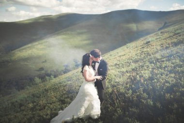 Güzel düğün çift, gelin ve damat, arka planda dağların aşık