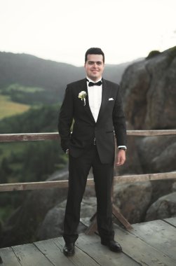 Şık adam, dağlar arka plan üzerinde poz damat