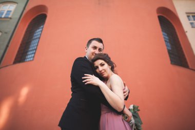 Muhteşem Düğün çifti, damat ve gelin pembe elbise Krakow eski şehirde yürüyüş ile